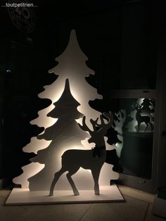 a lit up christmas tree with deer in it