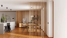 an open concept kitchen and dining area with wooden slats on the wall, hardwood flooring