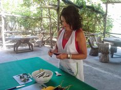 a woman standing in front of a table with food on it and looking at her cell phone