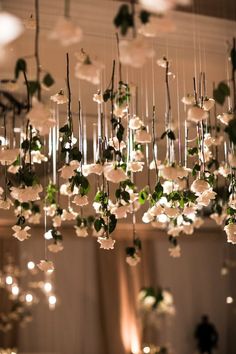 a chandelier with white flowers hanging from it's ceiling in a room