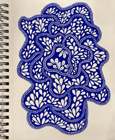 a spiral notebook with an intricate blue design on it