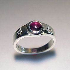 Two special stars, and an almandine garnet cabachon are the focal point on this hand carved, and cast, fun ring! The garnet measures 6mm, and is a beautiful raspberry color. It is bezel set, so there is no need to worry about prongs catching. This ring is sterling silver. This ring is made to order. Thanks for looking! Chris Celestial Ring, Almandine Garnet, Raspberry Color, Garnet Ring, Rings Cool, Garnet Rings