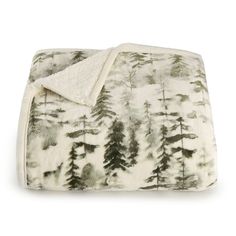 a blanket with trees printed on it and a white backing that is folded over the edge