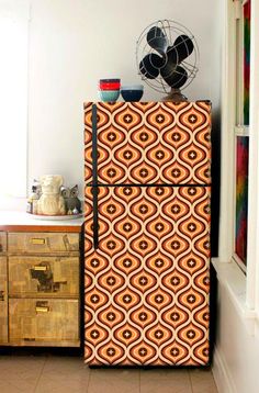 an old fashioned refrigerator is decorated with orange and brown designs