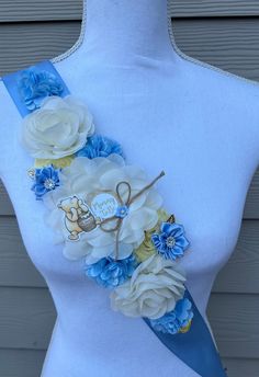 a white and blue sash with flowers on it