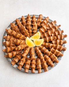 a plate with waffles and lemon wedges on it