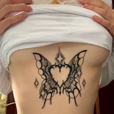 a woman with a butterfly tattoo on her stomach and the bottom part of her lower back