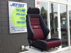 a red and black chair sitting in front of a building