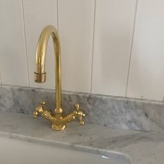 a gold faucet on a marble counter top