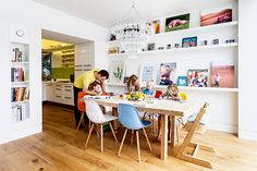 the family is sitting at the table in the kitchen and eating dinner with their children