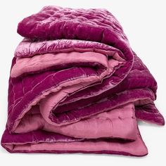 a pile of purple blankets folded on top of each other