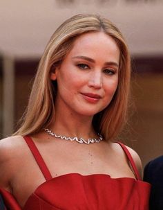 a woman in a red dress is smiling at the camera