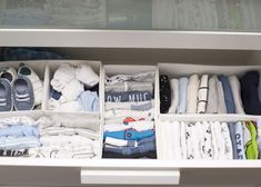 a drawer filled with lots of clothes and other items on top of a white shelf