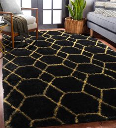 a black and gold rug in a living room with a couch, chair and potted plant