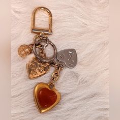 a heart shaped keychain with two keys attached to it on a furry surface