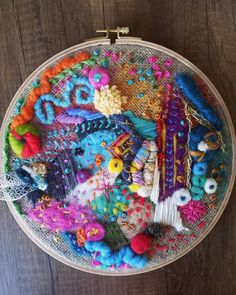 a close up of a embroidery on a wooden surface with beads and other things in it