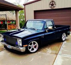 a black truck parked in front of a garage