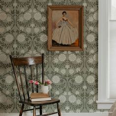 a chair sitting in front of a wall with a painting hanging on it's side