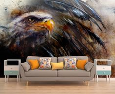 a living room with a couch and large painting on the wall behind it that has an eagle's head