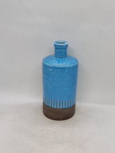 a blue vase sitting on top of a white table next to a black and brown object