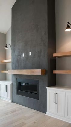 an empty living room with a fireplace and built - in shelving