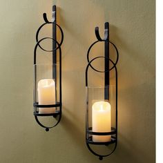 two wall mounted candle holders with candles in them