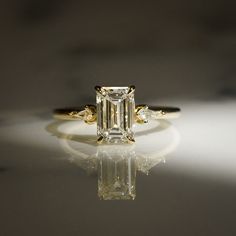 an engagement ring with a large diamond in the center and three smaller diamonds on each side