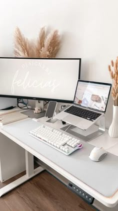 a computer desk with a laptop, keyboard and mouse on it in front of a white wall