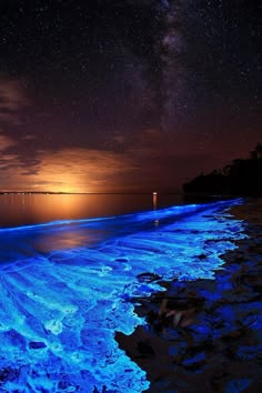 the water is glowing blue and it looks like waves are coming in from the ocean