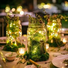 mason jars filled with moss and lit candles