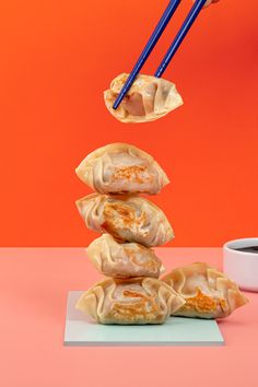 some dumplings are stacked on top of each other with chopsticks sticking out of them