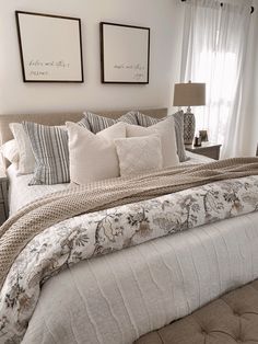 a large bed sitting in a bedroom next to two framed pictures