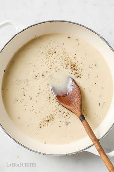 a wooden spoon in a pot filled with soup