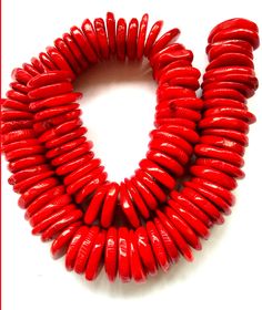 red beads are arranged in a circle on a white surface