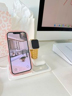 an apple watch and cell phone on a desk next to a computer monitor with the home screen open