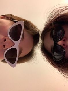 two women with sunglasses on their faces and one has her nose pressed against the other