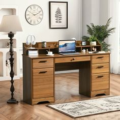 a wooden desk with a laptop on top of it in front of a lamp and window