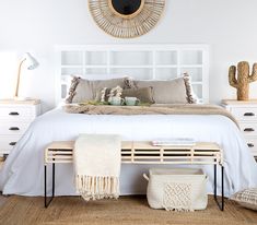 a bed with white linens, pillows and blankets on top of it in a bedroom