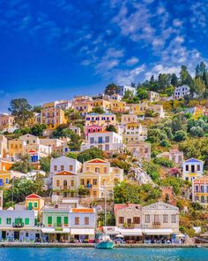 colorful houses are on the hillside by the water