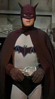 a man in a batman costume standing with his hands on his hips