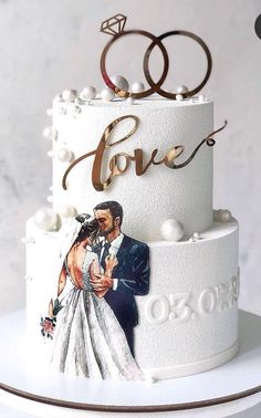 a wedding cake with two rings on top and an image of the bride and groom