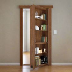 an open book shelf with books on it in a room that has wood floors and walls