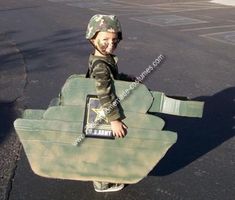 a young boy dressed up as a tank with a book in it's back