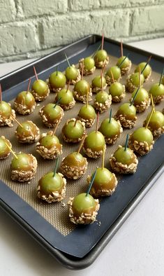 small snacks are arranged on a cookie sheet and lined with toothpicks, ready to be eaten