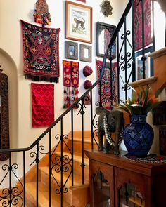 a stair case with pictures on the wall and an elephant figurine next to it