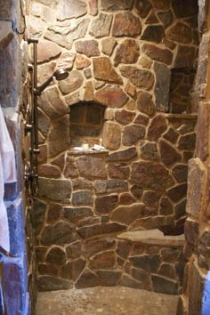 a bathroom with stone walls and a shower