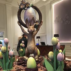 a statue of a rabbit surrounded by flowers and eggs