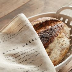 a loaf of bread sitting in a basket next to a napkin on top of a wooden table