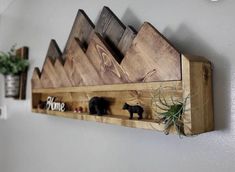 a wooden shelf with some small toy animals on it and an air plant in the middle