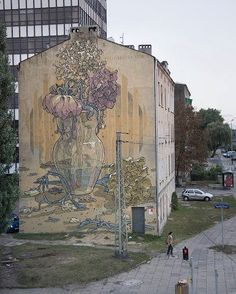 a large mural on the side of a building with flowers in a vase painted on it